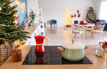 Coffee maker and cooking pot on stove in kitchen decorated for Christmas