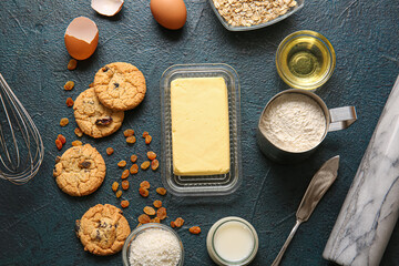Fototapeta na wymiar Fresh butter and ingredients for preparing homemade cookies on black background