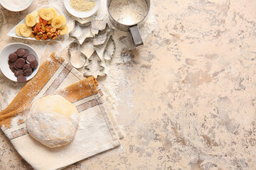 Fresh dough and ingredients for preparing homemade cookies on beige background