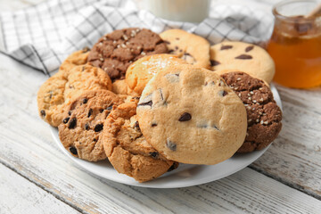 Plate with tasty homemade cookies on white wooden background