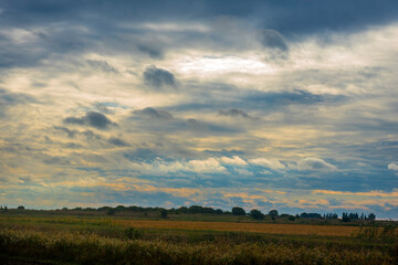 Fototapeta na wymiar sunrise and clouds over the field in autumn