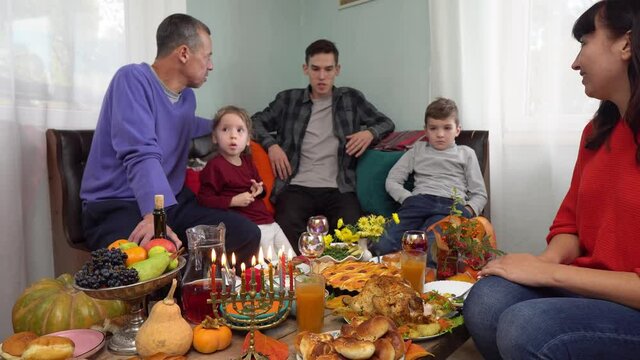 Jewish family have a dinner together at home. Hanukkah menorah. Traditional festive kosher food on the table