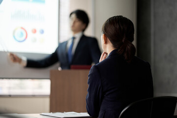 会議でプレゼンを聞くアジア人ビジネスウーマン