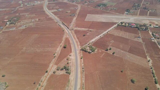 Long aerial over a highway running through a beautiful countryside in rural Kenya
