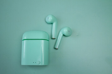 bluetooth headphones, green headphones, headphone container,  green background