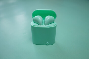 bluetooth headphones, green headphones, headphone container,  green background
