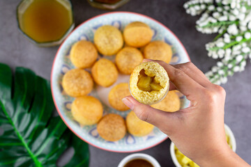Indian traditional snack. Flat lay hand holding Pani puri with boiled potato and sauce.