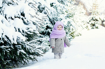 Little girl having fun at winter day on the big snow. Outdoor fun for family Christmas vacation. Winter activities for kids. Cute toddler enjoying a day out playing in the winter forest