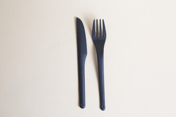 black plastic knife and fork isolated on light background flat lay