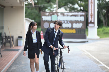 Two young business people walking on city street during a morning commute.