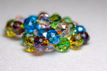 Full frame macro abstract texture background of a string of defocused multicolor glass beads on white background
