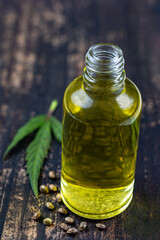 Organic hemp vegetable oil with leaf and seeds wooden background