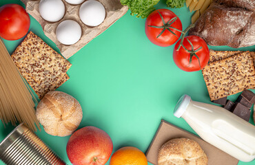 Vegetables, fruits, eggs, groceries on a green background top view. Set of fresh products in an online shop with home delivery and a healthy variety of food