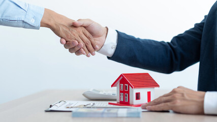 The real estate concept the house estate and his client shaking hands for accepting to make the land sale contract