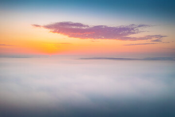 Naklejka na ściany i meble Bird's eye view of the fantastic ocean of clouds at sunrise. Aerial photography, drone shot.