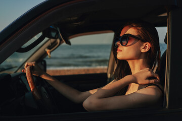 Obraz na płótnie Canvas cheerful woman in sunglasses driving a car trip travel