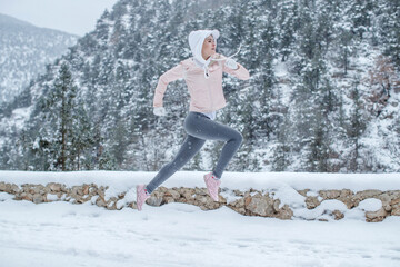The woman goes in for sports. The girl runs in the winter. High quality photo