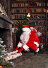 elf and Santa Claus add firewood to the fireplace for New Year's Eve and Christmas 2022