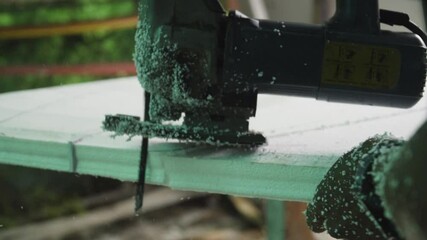 Cutting off polystyrene foam piece of blank surfboard with jig saw, shaping shortboard - Powered by Adobe