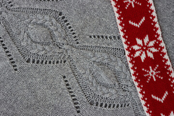 Gray decorated knitted wool background with red and white Christmas  wool scarf. Christmas festive background
