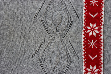 Gray decorated knitted wool background with red and white Christmas  wool scarf. Christmas festive background