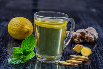 Ginger lemon herbal remedy infusion on a dark background