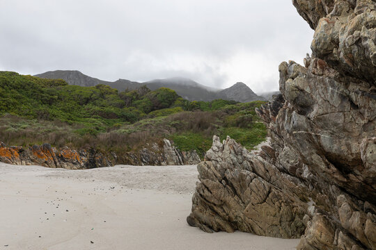 The jagged rocks and coastline of the Atlantic coast at Grotto Beach, a wide beach near Hermanus. 
