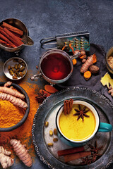 Healthy turmeric golden milk on dark background.