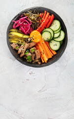 Bibimbap with snacks on gray background.