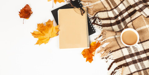 Autumn composition. Cup of coffee, glasses, plaid, notepad, autumn leaves on white background. Flat lay, top view, copy space. Concept of hot drinks in autumn