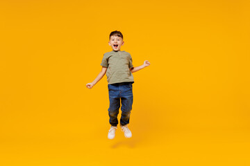 Full body overjoyed excited little small smiling happy boy 6-7 years old wearing green t-shirt jump...