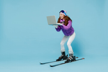 Full size skier happy woman in warm purple padded windbreaker jacket ski goggles mask spend extreme...
