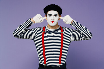 Angry sad young mime man with white face mask wear striped shirt beret closed eyes cover ears with hands fingers do not want to listen isolated on plain pastel light violet background studio portrait