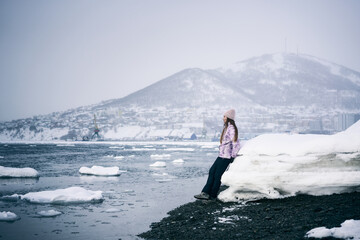 Portrait of smiling woman standing on ice on the coast of ocean