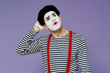 Puzzled thoughtful gloomy young mime man with white face mask wear striped shirt beret look up rub head iterates over solution options isolated on plain pastel light violet background studio portrait