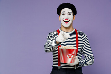 Laughing young mime man with white face mask wear striped shirt beret old bucket of popcorn watch...