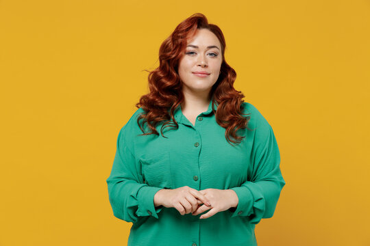 Charming bright happy young ginger chubby overweight woman 20s years old wear green shirt looking camera smiling isolated on plain yellow background studio portrait. People emotions lifestyle concept