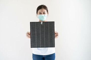 Asian woman wearing a hygiene protective face mask during changing a dirty air filter in the air...