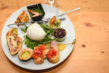 Assorted Appetizers In A White Plate On Wood