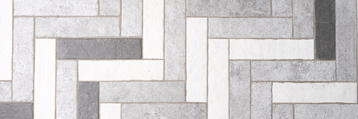Mosaic floor tiles in rectangles in shades of gray and white closeup