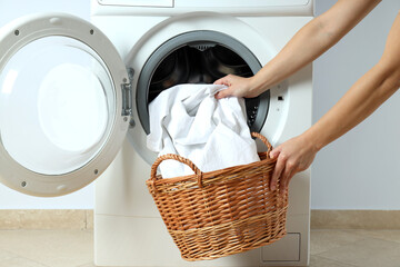 Concept of housework with washing machine against white wall - obrazy, fototapety, plakaty