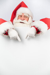 Santa Claus points to white copy space. Advertising. Merry Christmas.