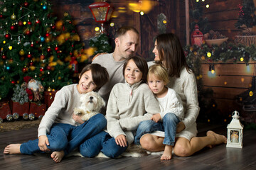 Happy family with children and pet dog, enjoying Christmas time together, celebrating