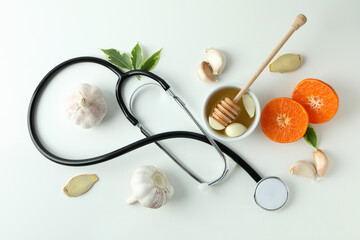 Concept of treatment colds with honey and garlic on white background