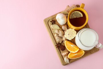 Concept of treatment colds with honey and garlic on pink background