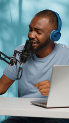 Influencer using podcast equipment and headphones recording on camera. Vlogger filming video with modern equipment and gear for online podcast on social media. Blogger with technology