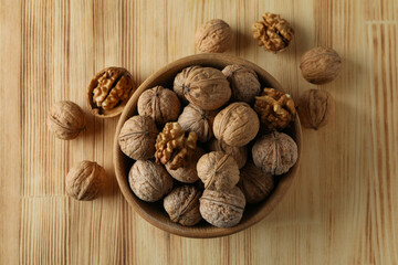 Walnuts in wooden bowl on wooden background