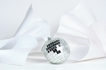 Christmas decoration in the form of a disco ball on a white textured background discards reflexes