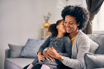 Cute african-american girl, kissing her mother's cheek.