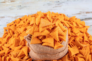 Portion of cone shaped snack tornado shaped crackers. Yellow spicy potato cone chips texture or...